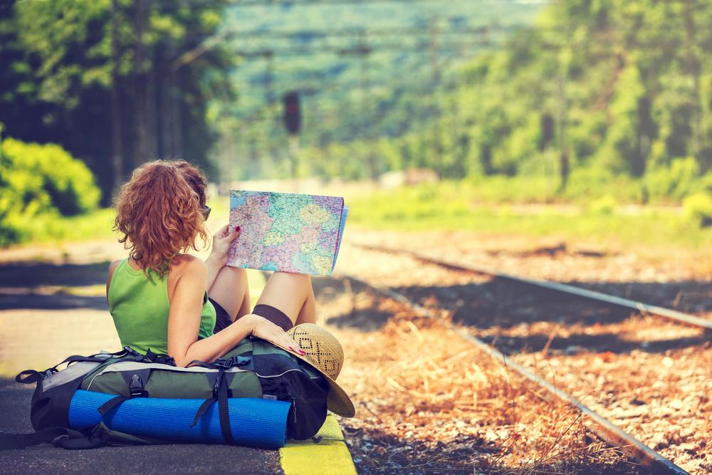 Girl,Wearing,Backpack,Holding,Map,,Waiting,For,A,Train